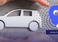 Paper-cut white car between hands with a blue map pin pointing to Jersey City, New Jersey (NJ).